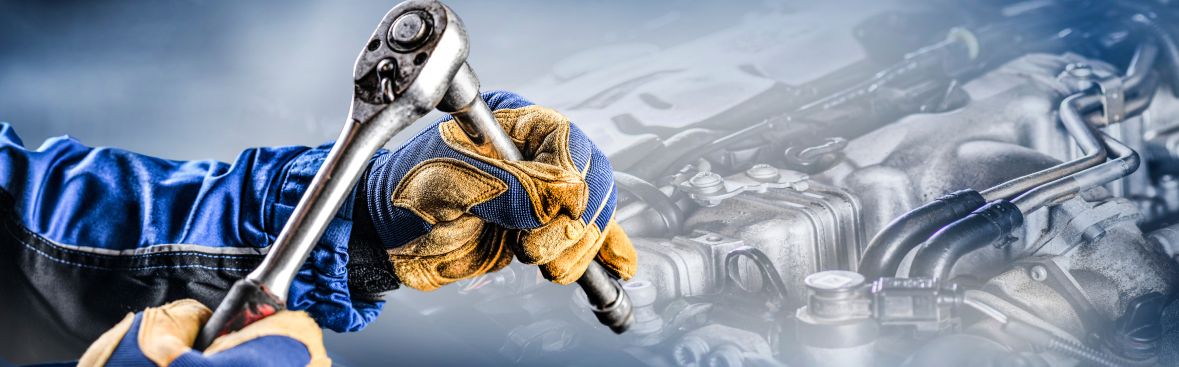Person schraubt an einem Motor